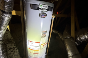 Newly installed A.O. Smith ProLine tank water heater in an attic, with the temperature and pressure valve, copper takeoff and yellow gas connector